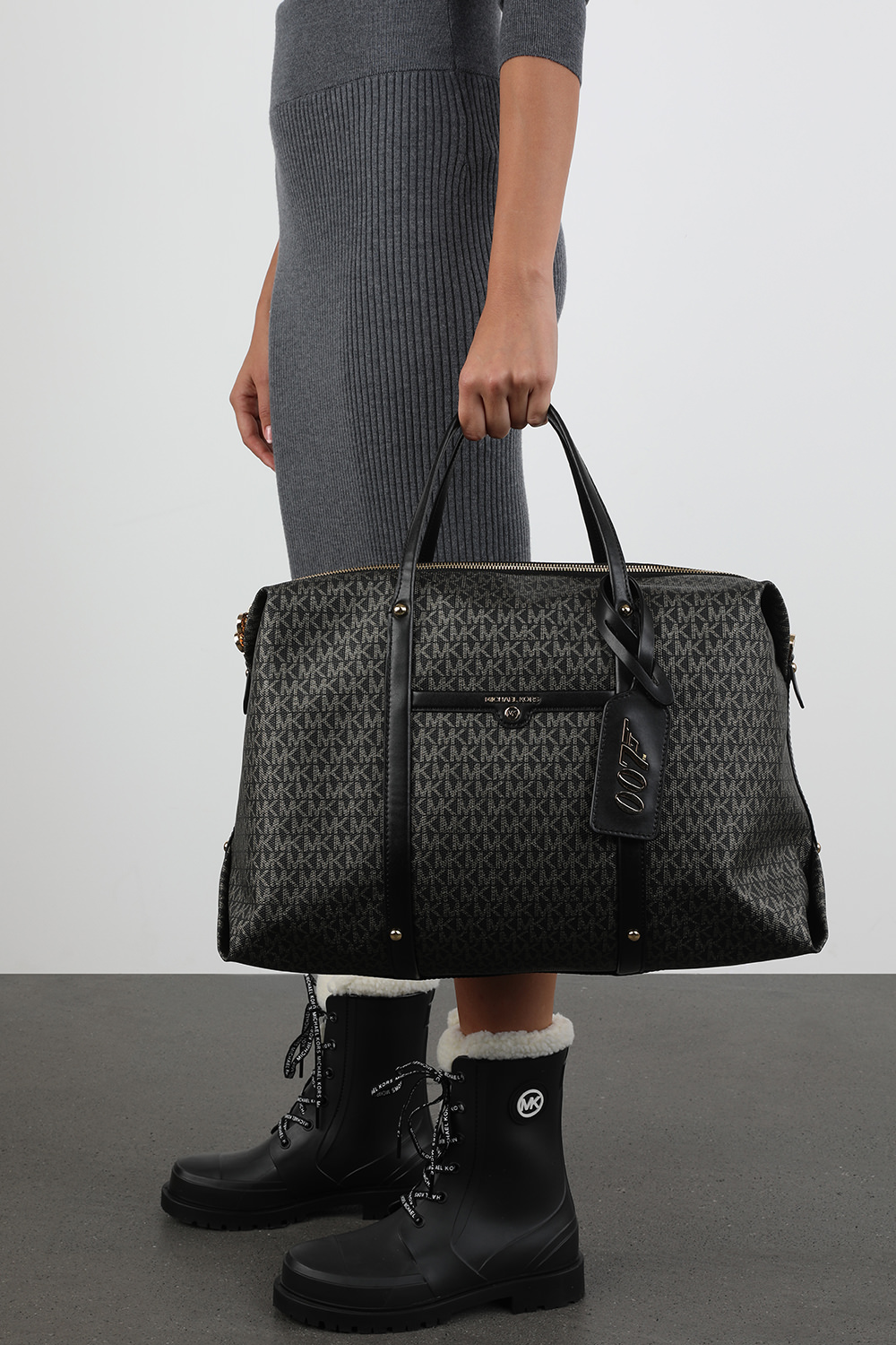 תמונת כל הלוק של מייקל קורס X 007 ג'יימס בונד תיק צד בק בצבע שחור מונוגרמי